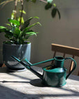 haws green watering can on the table